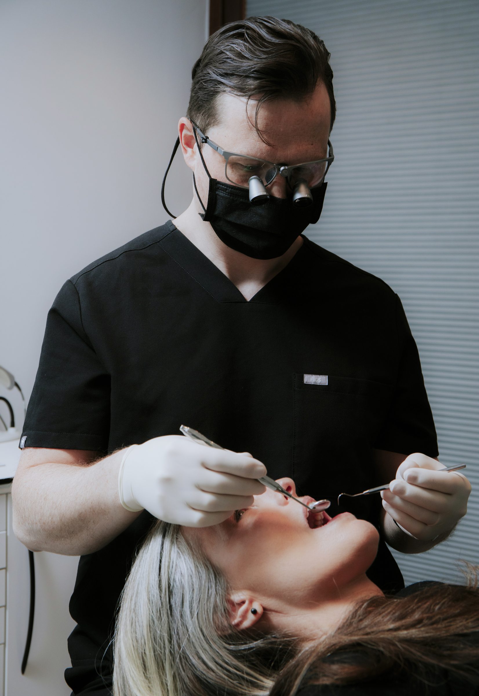 Dr. Daniel Wiens mit Lupenbrille bei der Untersuchung